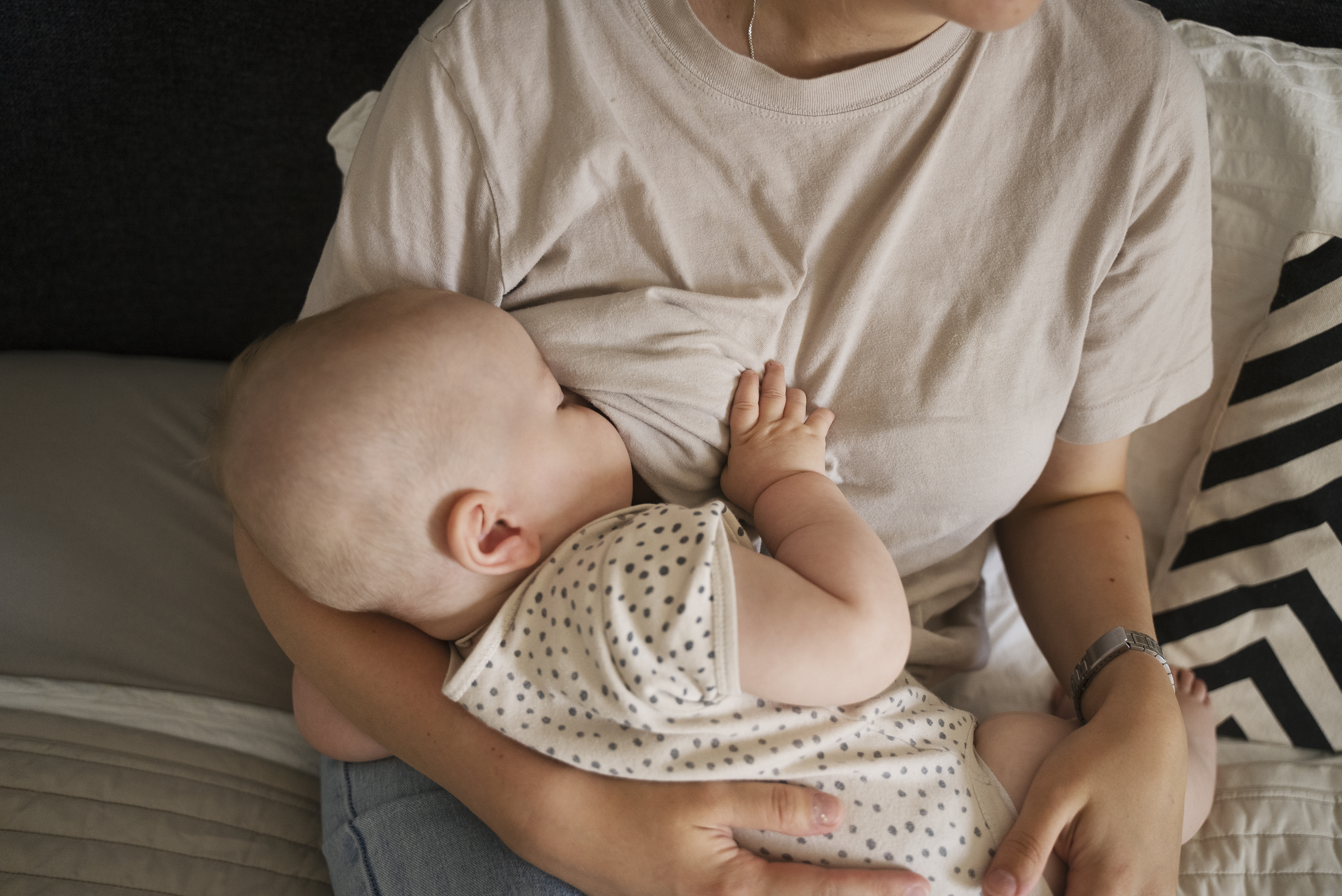 A mother breastfeeding her baby indoors