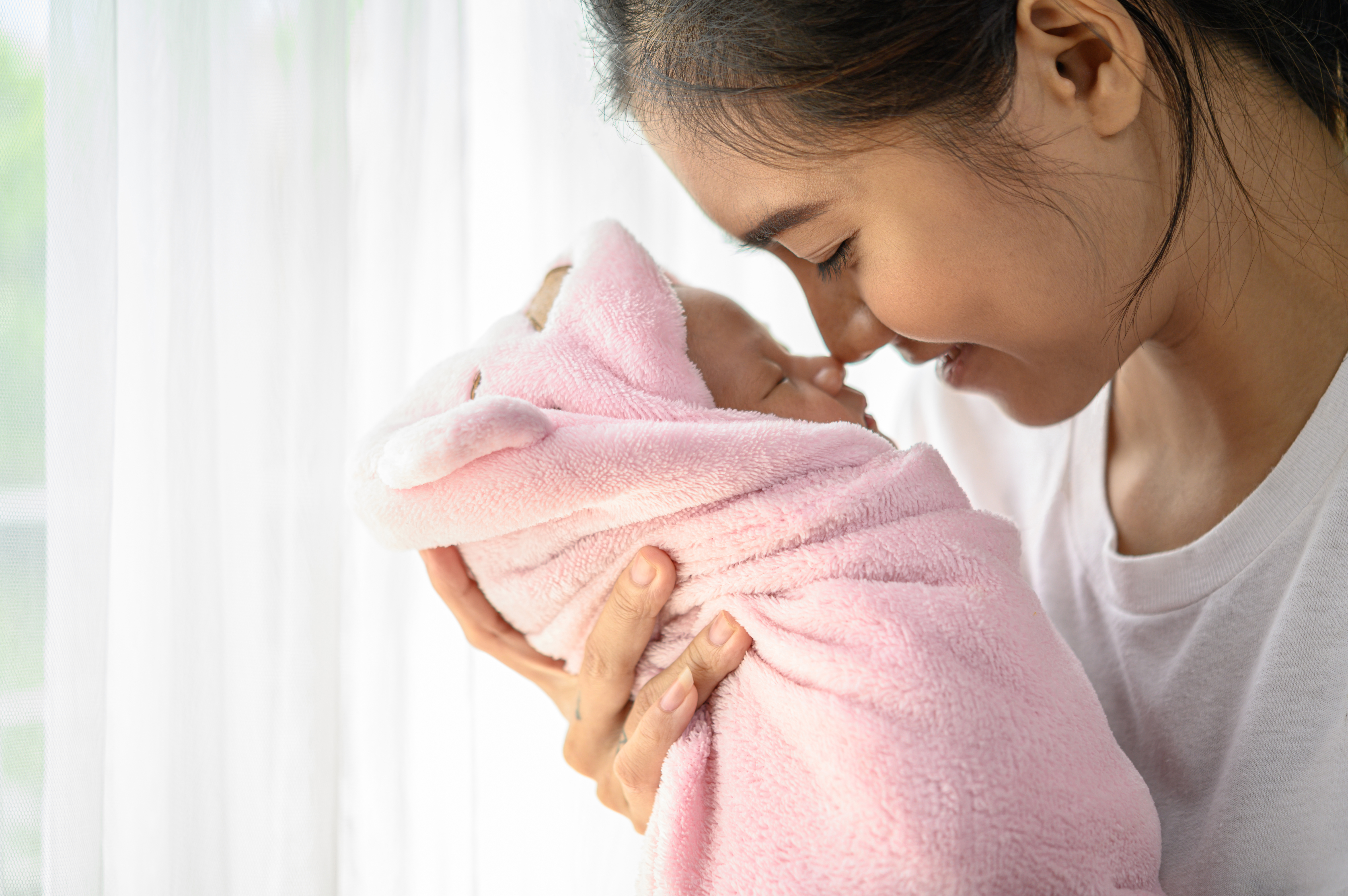 A newborn baby sleeping in mother's hands