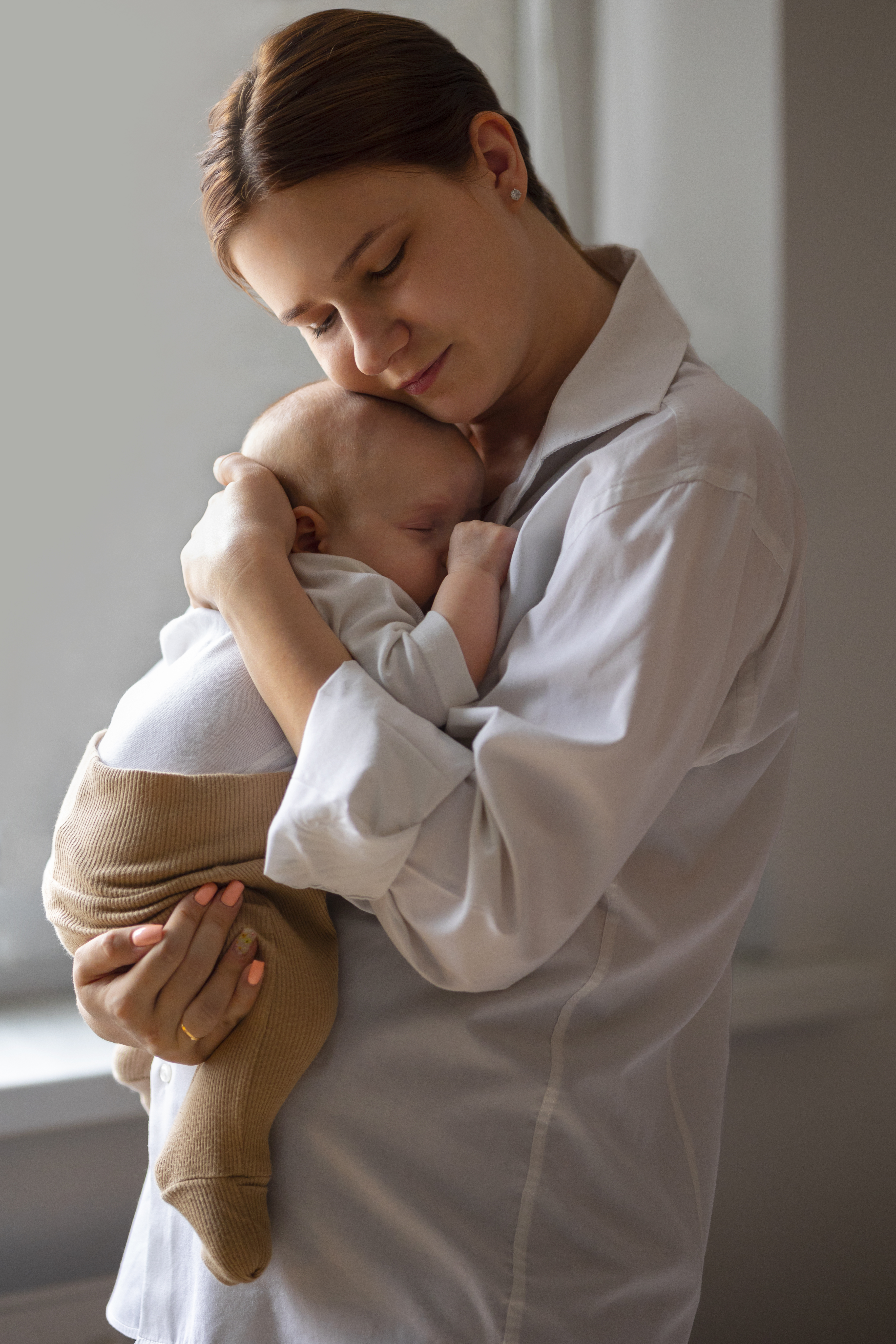 A mother holding her baby at home